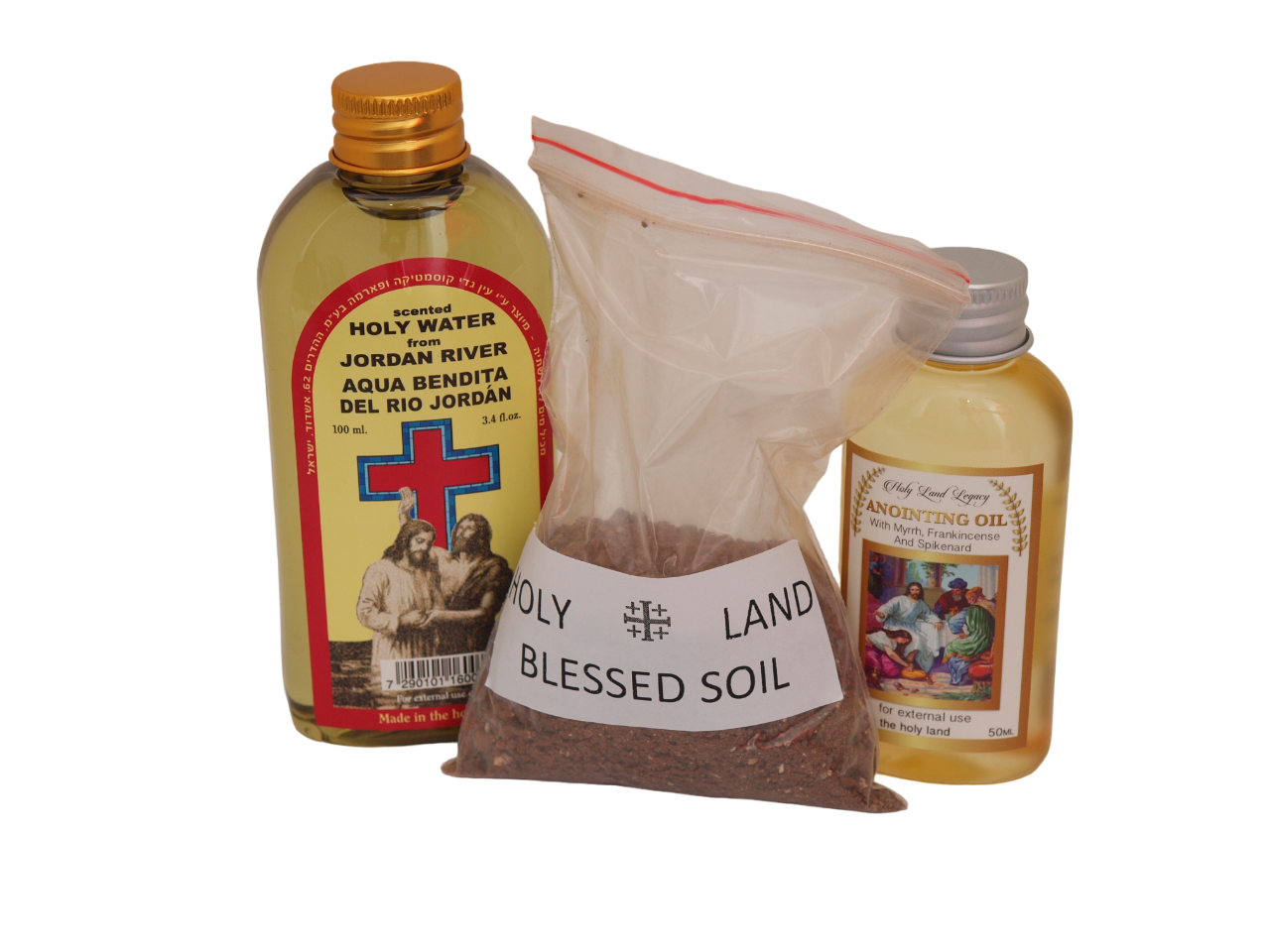 Three Holy Land items on white: a bottle of holy water from the Jordan River with a red cross on the label, a clear bag labeled Holy Land Blessed Soil, and a small bottle of anointing oil